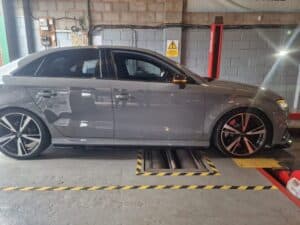 Side view of a grey car inside our garage, positioned and ready for vehicle maintenance and repairs